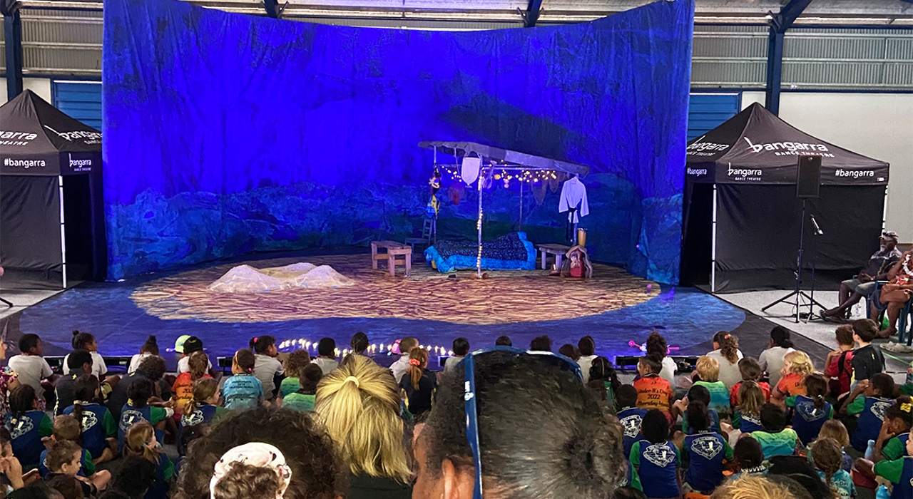 Photo of the Waru - journey of the small turtle set on the floor of a large sports complex. An audience of 400 people sit in the stands looking at the stage.